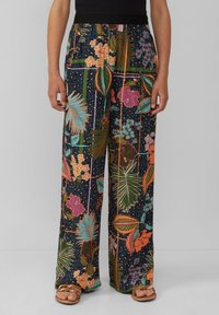 Wide-leg pants in dark fabric featuring vibrant floral and leaf patterns in orange, pink, and teal. Elastic waistband for comfort.