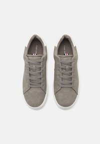 Gray suede sneakers with a smooth finish, featuring gray laces, a white rubber toe cap, and minimal branding on the insole.