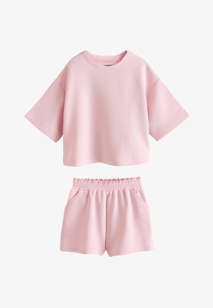 Set casual roz moale cu top oversize cu mânecă scurtă și pantaloni scurți cu talie elastică și buzunare laterale.