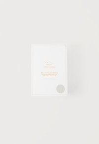 Άσπρο κουτί με την ετικέτα «Baby Essentials Gift Box» με χρυσά γράμματα και κυματιστό περίγραμμα σε απλό λευκό φόντο.