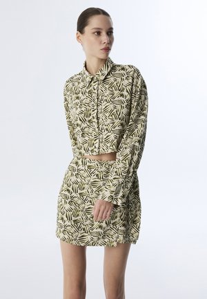 Geknipte blouse met knoopsluiting en bijpassende mini-jurk in lichtbeige met groene abstracte patronen, met lange mouwen en een kraag.