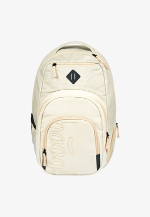 Beige fabric backpack with a diamond patch, zipper accents, and a prominent stitched logo. Two side pockets and padded straps.