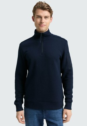 Marineblauer Zip-Up Sweatshirt aus strukturiertem Stoff, mit hohem Kragen und gerippten Bündchen. Enthält ein Schulterdetail und einen geraden Saum.