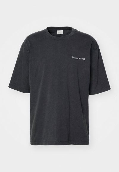 T-shirt en coton gris foncé avec col rond et manches courtes. Présente le texte "FILLING PIECES" brodé en blanc sur la zone du côté gauche de la poitrine.