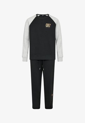 Conjunto de sudadera y pantalones en negro y gris. La sudadera cuenta con un cuello redondo, mangas raglán y la marca CR7. Los pantalones tienen una cinturilla elástica y cordón de ajuste.
