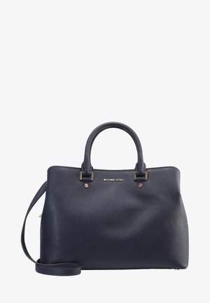 Mørkeblå Michael Kors læderhåndtaske med dobbelte håndtag, guldfarvet beslag og aftagelig skulderrem på hvid baggrund.