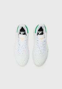 Valkoiset urheilukengät, joissa on tekstuurinen synteettinen päällinen, vihreät korostukset kauluksessa ja musta sisustus, jossa on Adidas-logo ja kolme raitaa.