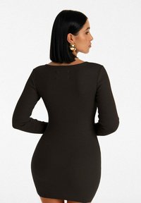 Czarna, długosleeve'owa sukienka z prążkowanej tkaniny o dopasowanej sylwetce i okrągłym dekolcie, z gładką teksturą i minimalistycznym wzornictwem.