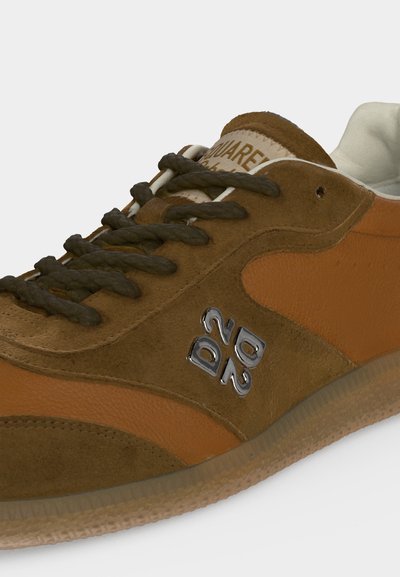 Baskets en daim et cuir marron avec lacets noirs et logo argenté "DSQ2" sur le côté, présentées sur fond blanc.