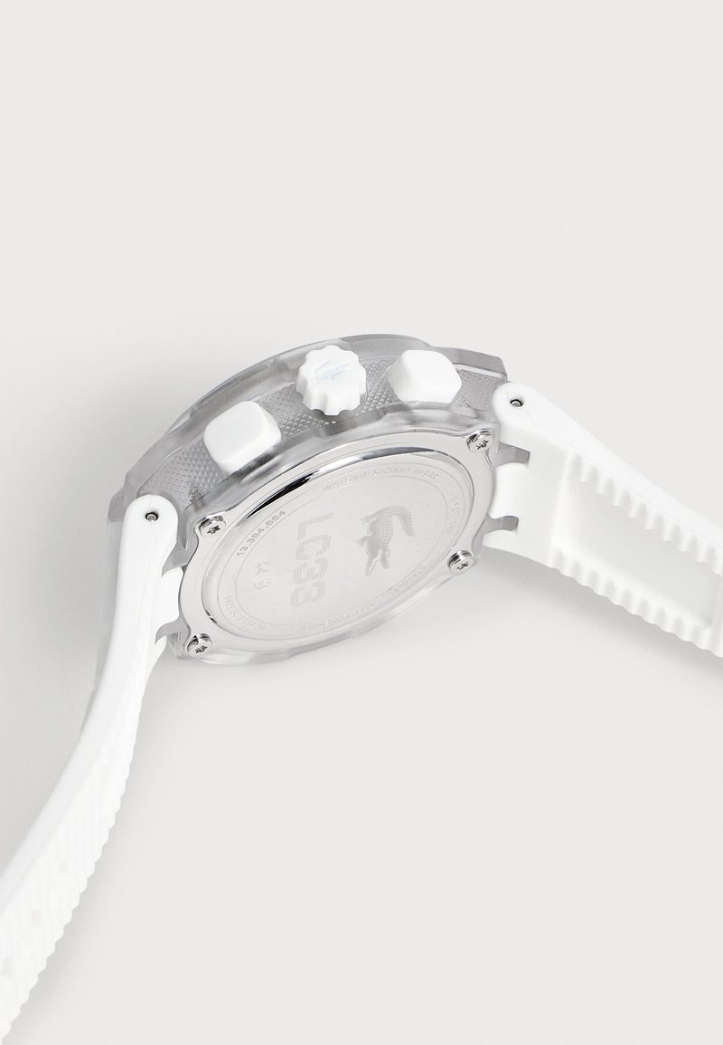Orologio digitale da polso bianco con cinturino testurizzato, tre pulsanti laterali e display parzialmente visibile su sfondo chiaro.
