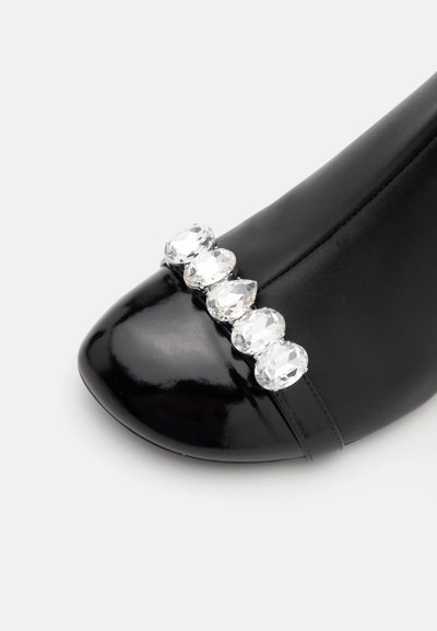 Black patent leather high heel with a rounded toe, featuring a row of five faceted clear rhinestones across the toe box.
