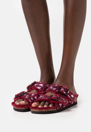 Pantoletten mit Fellfutter in Burgunderrot mit rosa Leopardenmuster, ausgestattet mit zwei verstellbaren Riemen und schwarzer Hardware, auf einer strukturierten Sohle.