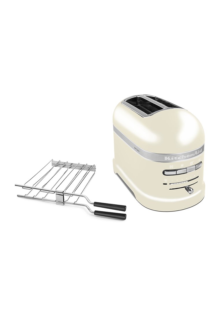 Grille-pain KitchenAid couleur crème avec deux fentes, accents chromés, un levier et des commandes à molette ; comprend un support à toasts en acier inoxydable.