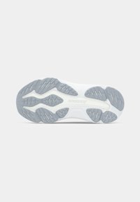 Hvid sneaker ydersål med en tekstureret gummioverflade, der har grå detaljer og et opdelt dækmønster for trækkraft. Logoet er synligt.