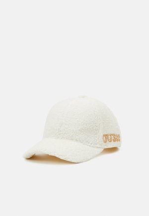 Casquette de baseball blanche en polaire texturée avec visière incurvée et logo "GUESS" brodé en orange sur le côté.