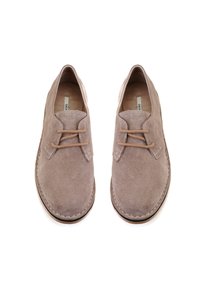 Chaussures en daim marron avec un bout arrondi, dotées de lacets beige et d'une semelle cousue couleur tan. Design minimaliste avec une texture lisse.