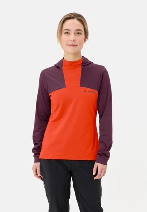 Rote und lila langärmelige Shirt mit Kapuze, das ein Farbblockdesign in kontrastierenden Farben aufweist und ein kleines Logo auf der Brust trägt. Weicher Stoff.
