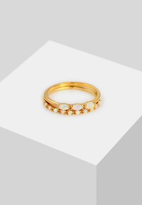 Anillo de oro con bandas dobles, con acentos de ópalo y pequeños cristales, textura suave y engastes ovalados. Diseño simple y elegante.