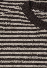 Knitted sweater with black and white horizontal stripes and a ribbed black round neckline.