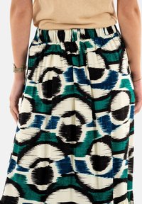 Gonna maxi con un motivo astratto blu, verde e nero su sfondo crema. Vita elasticizzata e trama di tessuto morbido.