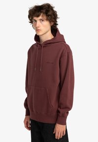 Mørkerød pullover hætte sweater, bomuldsblanding, kenguru lomme, snøre i hætten, blød tekstur, minimal logo på brystet, klassisk pasform.