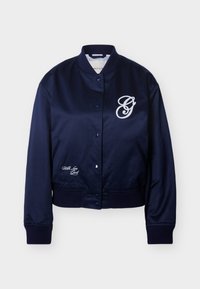 Veste bomber en satin bleu marine avec boutons-pression, poignets et ourlet côtelés, logo en script blanc sur la poitrine et le bas côté gauche.