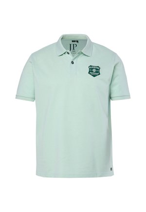 Jasnozielona koszulka polo z krótkim rękawem, dwoma guzikami i zielonym naszywanym logo na lewym kapturze z napisem "Mangroves National 1880."