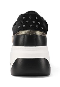 Sneaker nera con tomaia testurizzata, dotata di un tallone glitterato nero e accenti metallici dorati. La suola platform è bianca con una base nera.