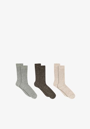 Trois paires de chaussettes montantes mouchetées en gris, marron foncé et beige, disposées côte à côte sur un fond blanc.