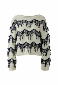 Cremfarbener Strickpullover mit cropped Design, ausgestattet mit marineblauen Fransen und Zickzackmustern entlang der Vorderseite und Ärmel. Rundhalsausschnitt.