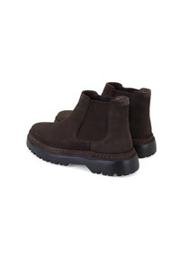Bottines en suède marron avec panneaux latéraux élastiques, semelle en caoutchouc noir texturé et coutures contrastantes marron.