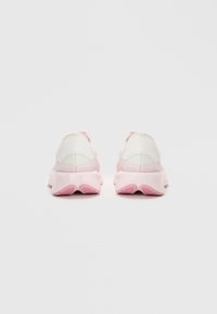 Et par lette rosa og hvite trening sneakers vist fra baksiden på en enkel hvit bakgrunn.