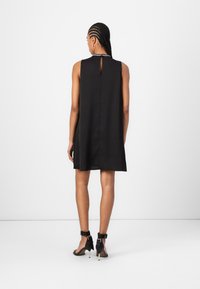 Black sleeveless dress with a keyhole back detail, made of smooth fabric, features a relaxed silhouette and falls above the knees.