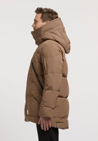 Hnedá nafukovacia bunda s vysokým golierom, rebrovanou kapucňou, bočným zipsovým vreckom a hladkou, prešívanou štruktúrou.