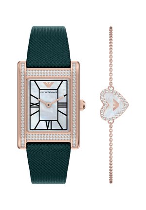 Reloj rectangular con correa texturizada verde, caja de oro rosa, esfera de nácar, marcadores de hora negros y detalles de cristal. Incluye pulsera con corazón.