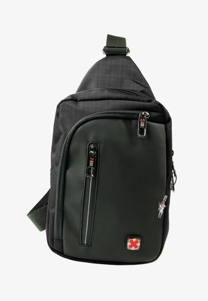 Compacte zwarte schouderrugzak met twee voorvakken met rits, verstelbare riem en ritsuiteinden en embleem met rode accenten.