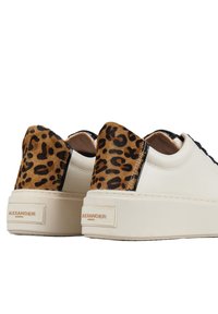 Scarpe di pelle con tomaia color crema, accenti in stampa leopardata marrone sul tacco e suola piatta beige. Logo impresso sul tacco.