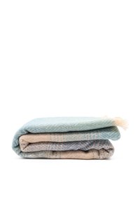 Tre coperte piegate: la superiore è di un blu chiaro con un motivo texture, quella centrale è beige con dettagli sottili, e quella inferiore è grigio-blu con una finitura intrecciata.