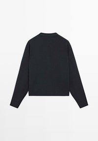 Sort langærmet crewneck-trøje lagt fladt ud, der viser bagsiden, med ribbede manchetter og kant på en hvid baggrund.