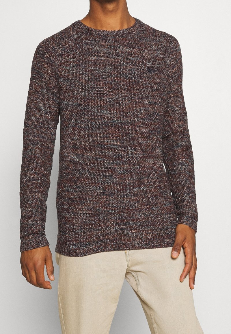 Strickpullover in einem strukturierten, mehrfarbigen Muster mit Schattierungen von Burgunderrot, Blau und Grau. Rundhalsausschnitt und gerippte Bündchen.