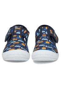 Tumesinised kingad automustriga oranži ja helesinisega. Omavad lõpplukke ja valge kummist tallaga, millel on sooniline tekstuur.