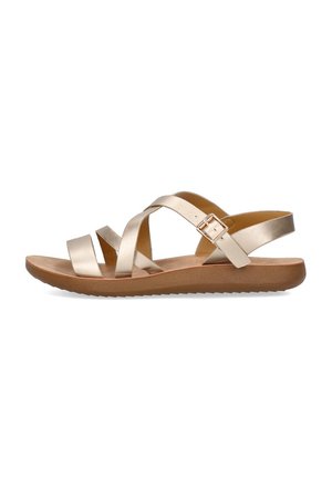 Sandalias metálicas doradas con múltiples tiras cruzadas, hebilla ajustable y suela de goma. Diseño plano con una textura suave.