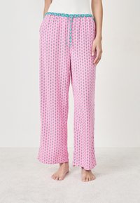 Różowe spodnie piżamowe z powtarzającym się wzorem graficznym, luźny krój, elastyczny pas z turkusowym sznureczkiem i miękka tekstura.