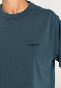 Turkusowa bawełniana koszulka z ribbowym wzorem, z małym czarnym logo "element" na klatce piersiowej i klasycznym okrągłym dekoltem.