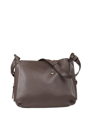 Sac bandoulière en cuir brun texturé avec une sangle ajustable et un petit porte-bonheur en forme de drapeau rouge, blanc et vert fixé près de la fermeture éclair.