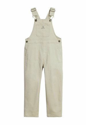 Beige Baumwoll-Kinder-Overall mit verstellbaren Schultergurten, vorderer Brusttasche mit Logo, seitlichen Knopfverschlüssen und Seitentaschen.