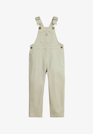 Beżowy bawełniany kombinezon dziecięcy z regulowanymi szelkami, przednią kieszenią na piersi z logo, zapinanymi na guziki po bokach oraz bocznymi kieszeniami.