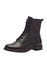 Bottine en cuir marron avec un bout arrondi, un laçage à l'avant et un logo circulaire sur le côté. Semelle robuste avec un léger talon.