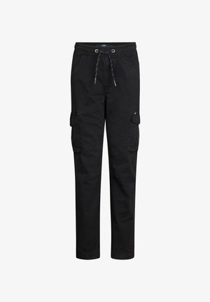 Camicia a maniche lunghe gialla chiara con stampa grafica sul petto, abbinata a pantaloni cargo neri e sneakers bianche.