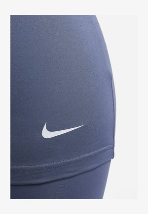 Navy-Fitness-Leggings aus Stretchstoff mit einem weißen Nike-Logo an der Seite, einem glatten Textur und einem figurbetonten Schnitt.